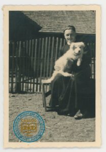 Ks. Teofil Świątek z owczarkiem Miśkiem przed domem Magdaleny i Wincentego Baniaków