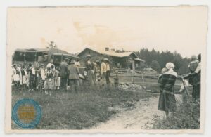 Grupa osób przed samochodem wojskowym