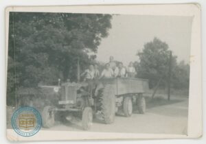 Mężczyźni na traktorze w czynie społecznym