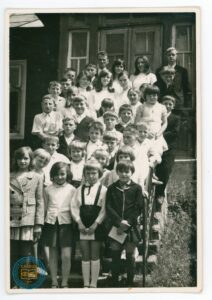 Nauczyciele z uczniami na schodach szkoły w Nowicy