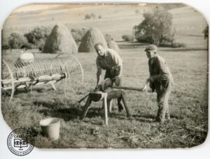 Michał Bołdyś i Stefan Dyczko ostrzą kosę do kosiarki