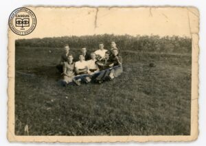 Grupa chłopców i dziewczyn na łące z koszykiem