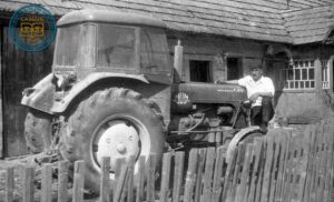 Władysław Kozyra pozujący oparty o traktor